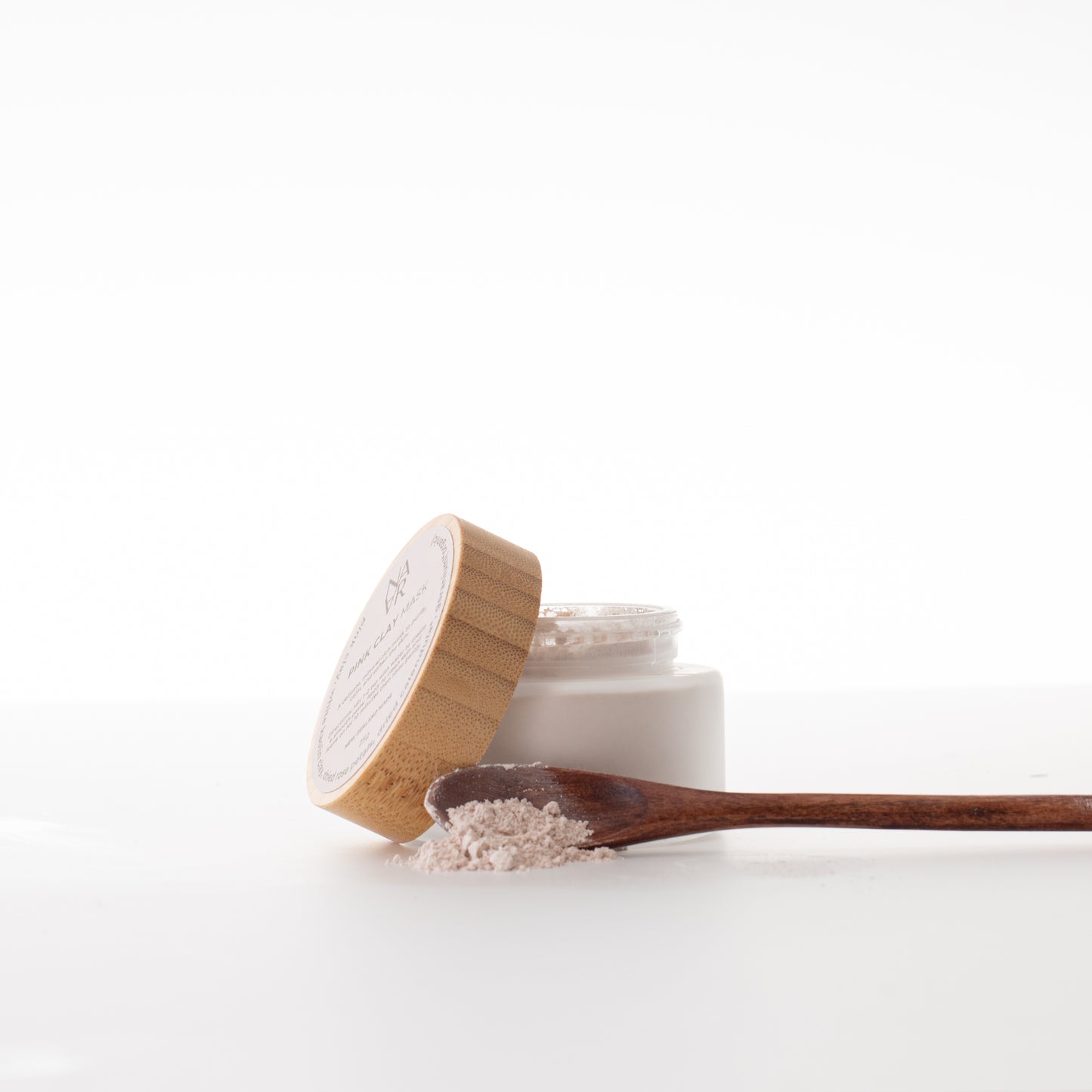 Natural Pink clay mask in eco-friendly container with wooden lid on a white background. Wellness for women / NARA